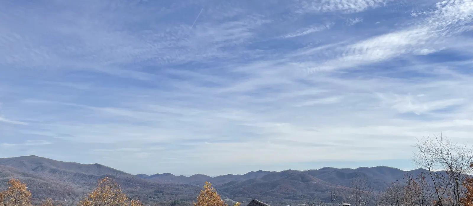 Layered blue mountain ridgelines under thin cloud, seen from Pinnacle Drive below the lot